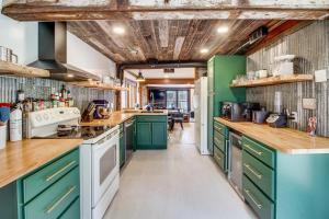 a kitchen with green cabinets and white appliances at Waterfront Duluth Cabin with Deck and River View! in Duluth