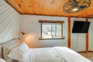 a bedroom with a bed and a flat screen tv at Waterfront Duluth Cabin with Deck and River View! in Duluth