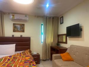 a bedroom with a bed and a couch and a flat screen tv at ULTIMATE HOTEL in Tokuse