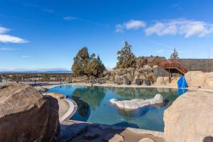 - une grande piscine dans un complexe avec des rochers dans l'établissement Luxurious Home Beautiful Views Family Friendly, à Powell Butte