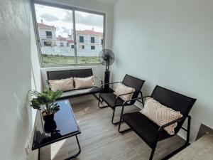 ein Wohnzimmer mit Stühlen, einem Tisch und einem Fenster in der Unterkunft Casa Dom Simões in Aljezur