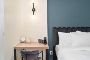 een slaapkamer met een bed en een bureau met een spiegel bij Clouds Boutique Hotel in Montreal