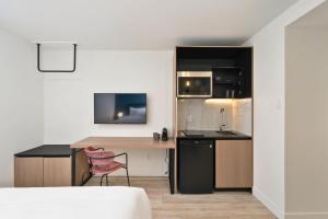 a small kitchen with a desk and a chair at Clouds Boutique Hotel in Montreal