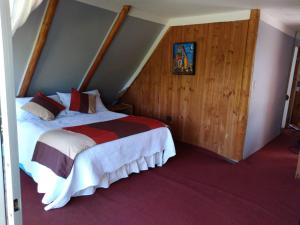 a bedroom with a large bed in a attic at Cabaña Elu in Llico