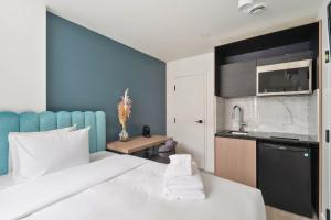 a hotel room with a bed and a kitchen at Clouds Boutique Hotel in Montréal