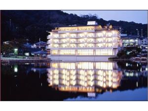 un edificio illuminato con il suo riflesso nell'acqua di Kotobukirou - Vacation STAY 01905v a Kobe