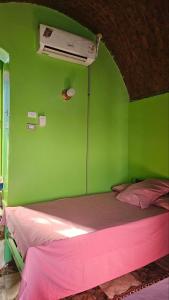 Cette chambre verte comprend un lit et un ventilateur. dans l'établissement Taam Al beeyout, à Naj‘ al Maḩaţţah