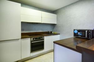 eine Küche mit weißen Schränken und einem schwarzen Backofen in der Unterkunft Luxueux Duplex 2CH dans une magnifique résidence in Marrakesch