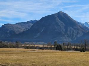 una montagna di fronte a un campo con un aquilone di Adventure Oasis Bovec a Bovec