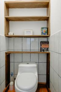 a bathroom with a white toilet in a room at Ocean view studio in Pelada! in Nosara