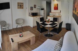 a living room with a table and chairs and a kitchen at Le Haut Berry in Les Aix-dʼAngillon