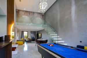 einen Billardtisch im Wohnzimmer mit einer Treppe in der Unterkunft Luxueux Duplex 2CH dans une magnifique résidence in Marrakesch