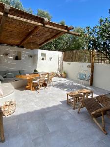 un patio con mesa, sillas y un columpio en koritos countryhouse, en Agios Leon