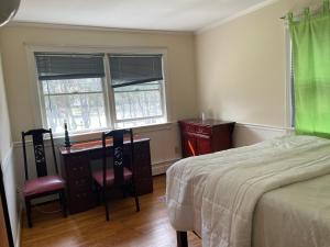 a bedroom with a bed and a desk and two chairs at Eusleep pleasure in Fairfax