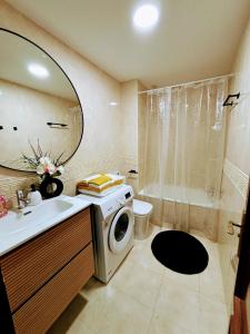 een badkamer met een wasmachine en een wastafel bij APARTAMENTO DE AMY CON VISTA AL MAR 2 in Huelva