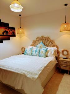 sypialnia z dużym białym łóżkiem z niebieskimi poduszkami w obiekcie APARTAMENTO DE AMY CON VISTA AL MAR 2 w mieście Huelva