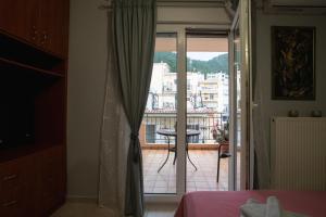 a bedroom with a door open to a balcony at RIRIKA APARTMENT in Igoumenitsa