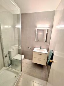 a bathroom with a toilet and a sink and a shower at Apartamento Playa Xoriguer con piscina y jardin in Son Xoriguer +27 photos