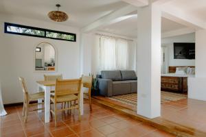 een woonkamer met een tafel en stoelen en een bank bij Ocean view studio in Pelada! in Nosara