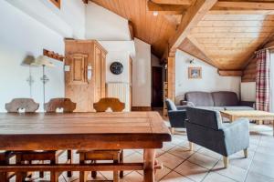 uma sala de jantar com uma mesa de madeira e cadeiras em Résidence La Ginabelle - maeva Home - Appartement 4 Pièces 8 Personnes - Séle 65 em Chamonix-Mont-Blanc