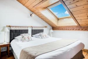 um quarto com uma cama grande e uma clarabóia em Résidence La Ginabelle - maeva Home - Appartement 4 Pièces 8 Personnes - Séle 65 em Chamonix-Mont-Blanc