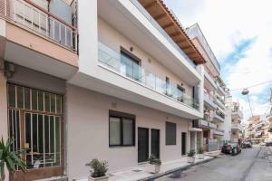een wit gebouw met een balkon in een straat bij Cozy apartment in a new building apartment 4 in Piraeus