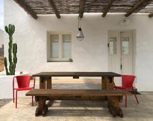 un tavolo in legno in un patio con 2 sedie e un cactus di Casas de Seixe a Baiana