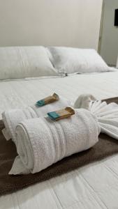a white bed with a towel on it at Pousada Shalon Adonai Noronha in Fernando de Noronha