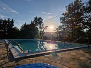 uma piscina com o pôr-do-sol ao fundo em Podere Poggio San Vito em Panicale