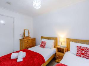 a bedroom with two beds with red and white pillows at 2 Bed in Keswick 86393 in Rosthwaite