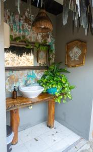 un baño con lavabo y una planta en un mostrador en Kite Eco House, en Salina de Rey