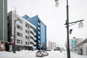 a car driving down a city street with buildings at 101 - Vacation STAY 16274 in Asahikawa