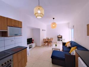 eine Küche und ein Wohnzimmer mit einem blauen Sofa in der Unterkunft Seaview Apartament, Playa Chica, Las Gaviotas, Apartamento 311 in Santa Cruz de Tenerife
