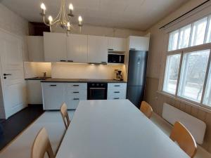 uma cozinha com uma grande mesa branca e cadeiras em Charming wooden house apartment 48 m2 em Turku