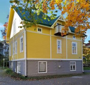 uma casa amarela e cinzenta com uma varanda em Charming wooden house apartment 48 m2 em Turku