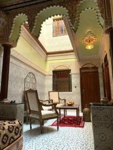 een woonkamer met 2 stoelen en een tafel bij Dar Amane - Charmante maison marocaine in Marrakesh