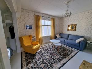 a living room with a blue couch and a yellow chair at Charming wooden house apartment 48 m2 in Turku