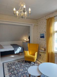 una camera con letto e sedia gialla di Charming wooden house apartment 48 m2 a Turku