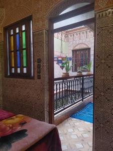 een kamer met een deur naar een balkon met glas-in-loodramen bij Dar Amane - Charmante maison marocaine in Marrakesh