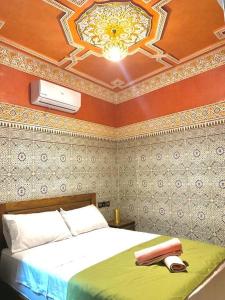 een slaapkamer met een bed en een plafond bij Dar Amane - Charmante maison marocaine in Marrakesh
