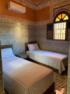 1 dormitorio con 2 camas y ventana en Dar Amane - Charmante maison marocaine, en Marrakech