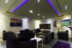 una sala de espera con sofás y TV de pantalla plana. en Rofan Hotel Suites en Riad
