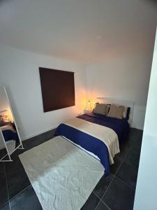 a bedroom with a bed with a blue comforter at Casa Daja: uw thuis in Tenerife in Las Lagunas