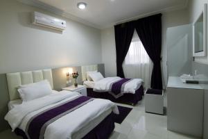 een hotelkamer met twee bedden en een raam bij Rofan house serviced apartments in Riyad +21 foto's