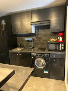 a kitchen with a washing machine and a washer at 13 Nuances De Grey jacuzzi in Marseille
