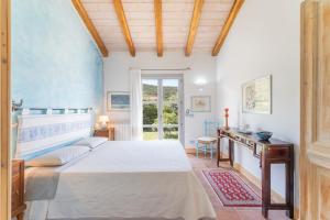 a bedroom with a bed and a table and a window at B&B Calata Di Soli in Miniera dellʼArgentiera