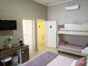 a bedroom with two bunk beds and a desk and a yellow door at Domos La Corte Ghibellina in Iglesias