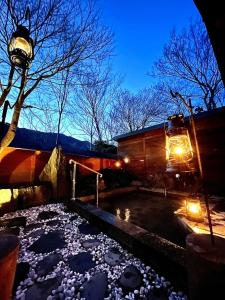 pokryty śniegiem dziedziniec z wanną z hydromasażem i lampą w obiekcie Nagatoro Camp Village - Vacation STAY 06872v w mieście Minano