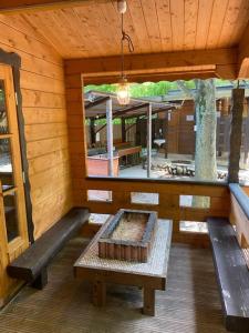 an inside view of a log cabin with a table and benches at Nagatoro Camp Village - Vacation STAY 06873v in Minano