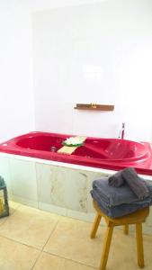 a red tub in a bathroom with a stool at Casa Zazen in Amatlán